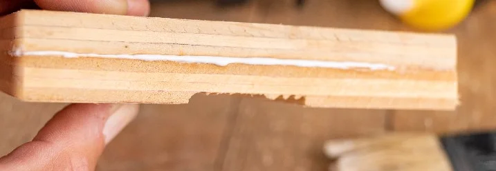 Hand hält verleimtes Sperrholz